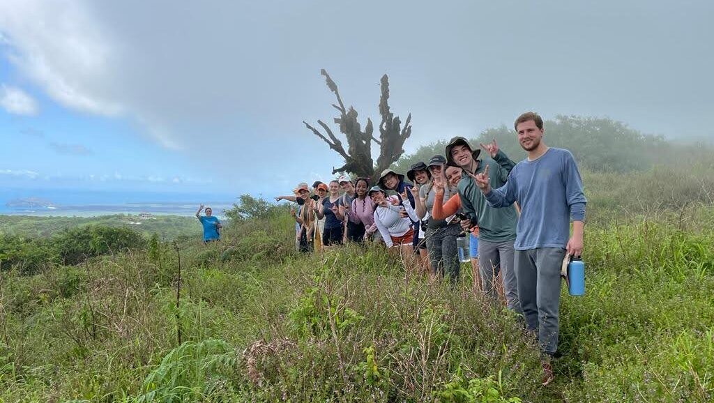 Group of students standing in a row on a hillside in the Galapagos islands
